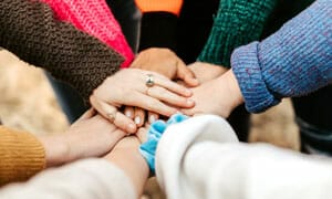 teamwork-hands-together-300×180